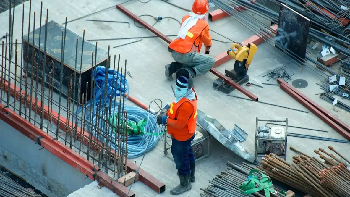 Construction project director and commercial manager reviewing live project cost, CVR, and site operations