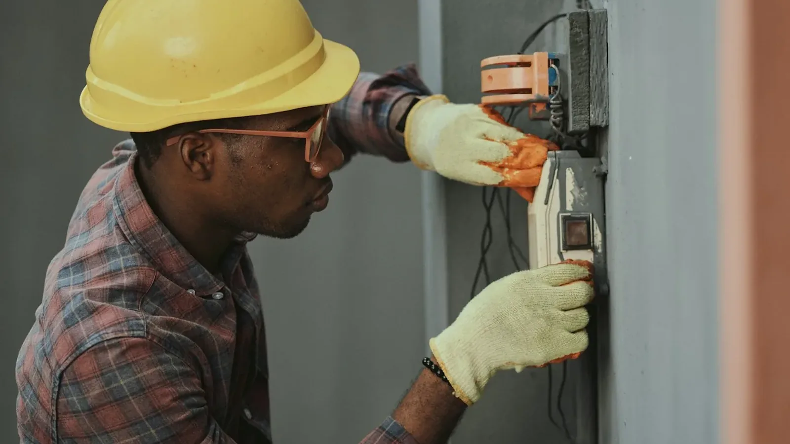 A technician working on building services switchgear
